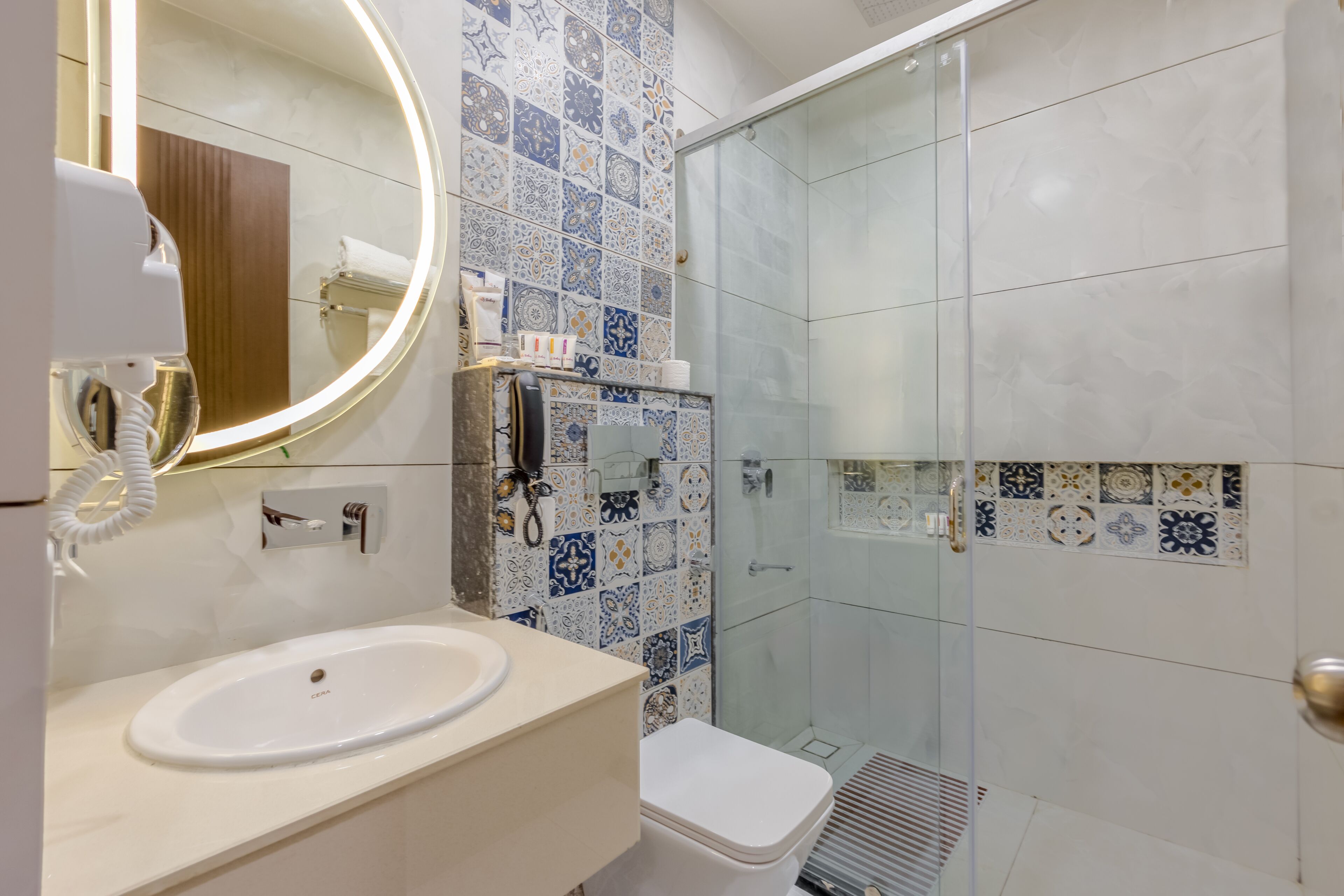 A bathroom with a sink, mirror, and shower.