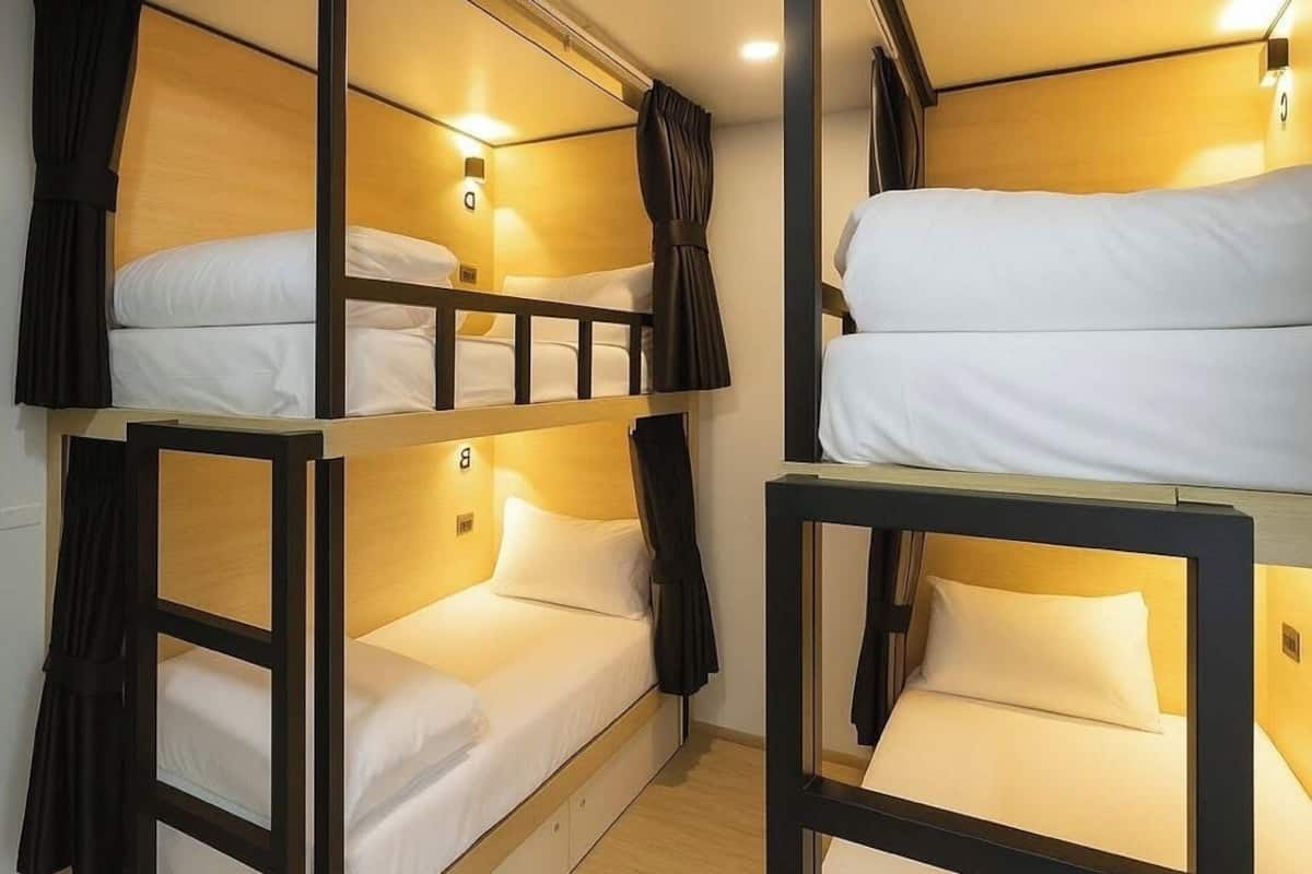 A bunk bed room with two beds, each with a headboard and curtains.