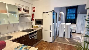 Una cucina moderna con isola centrale, elettrodomestici in acciaio inossidabile e pavimento piastrellato.