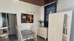 Una cucina moderna con mobili bianchi, un tavolo da pranzo con sedie e un soffitto in legno.