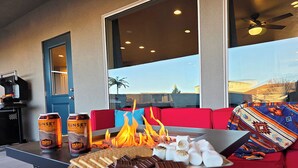 Une terrasse avec une table préparée pour un goûter, un canapé rouge et une vue sur l’extérieur.