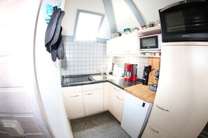 A compact kitchen with a microwave, coffee maker, and a dishwasher.