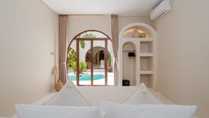 Une chambre avec vue sur une piscine et un espace extérieur aménagé pour se détendre.