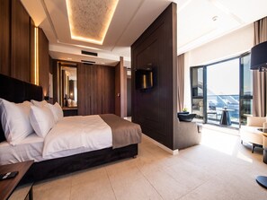 A modern hotel room with a large bed, a flat-screen TV, a balcony with a view, and a large window. - Premium hotel (Novi Sad)