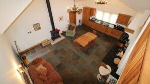 Un ampio loft con soffitto alto, zona pranzo, cucina e un angolo salotto accogliente con camino.