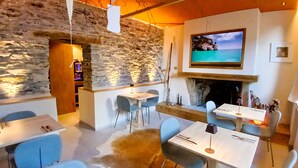 Ein modernes Interieur mit Steinwänden, einem Kamin und einem darüber montierten Fernseher.