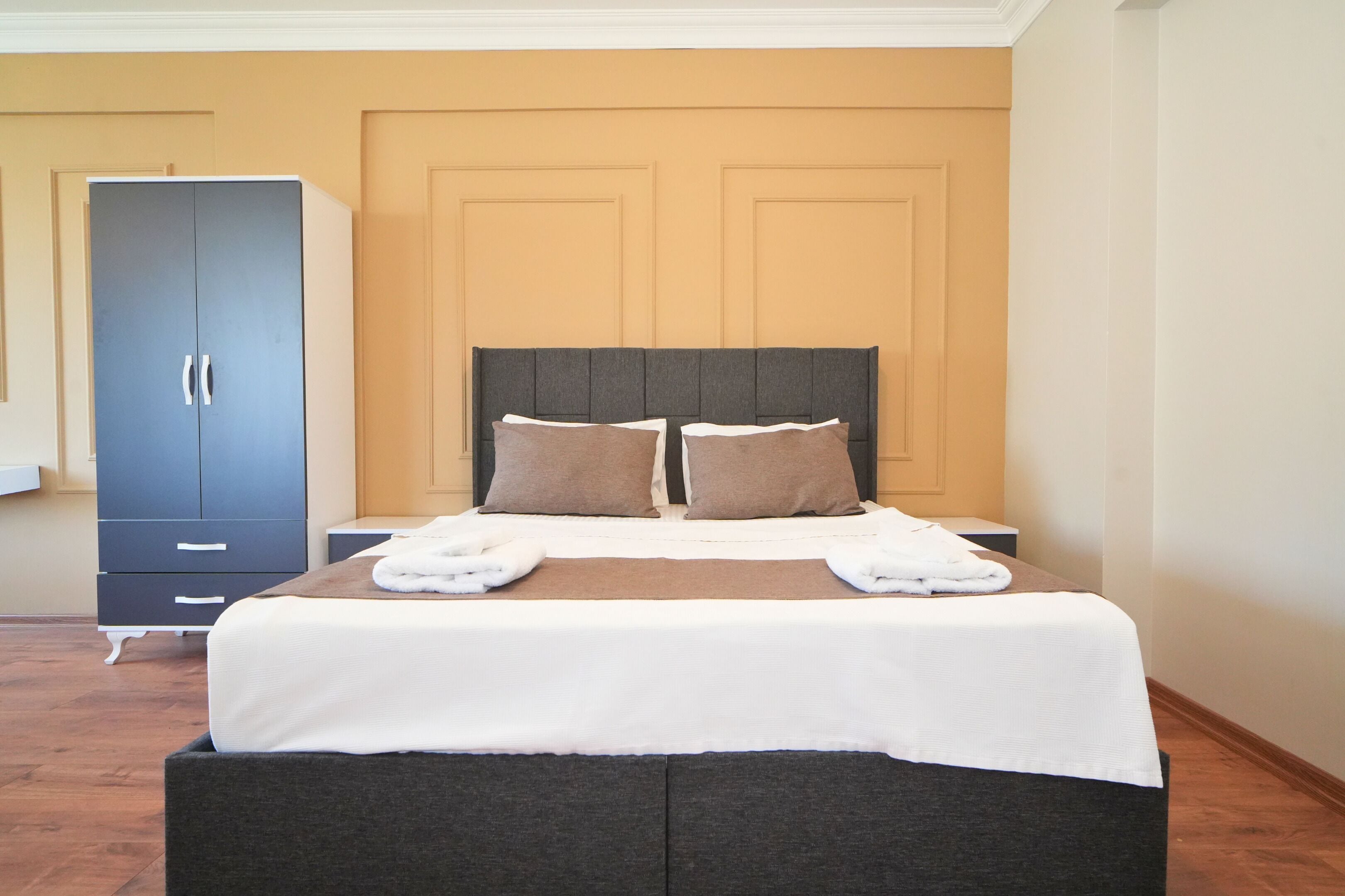 Una camera da letto con un letto, due cuscini, un comodino e un armadio.