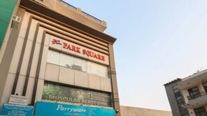 A building with a sign for 'Park Square' and a 'Muscular Beast Gym' below it. - Hotel Park Square Resort (Faridabad)