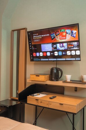 Televisor de pantalla plana montado en la pared, mostrando diversos servicios de transmisión y canales.