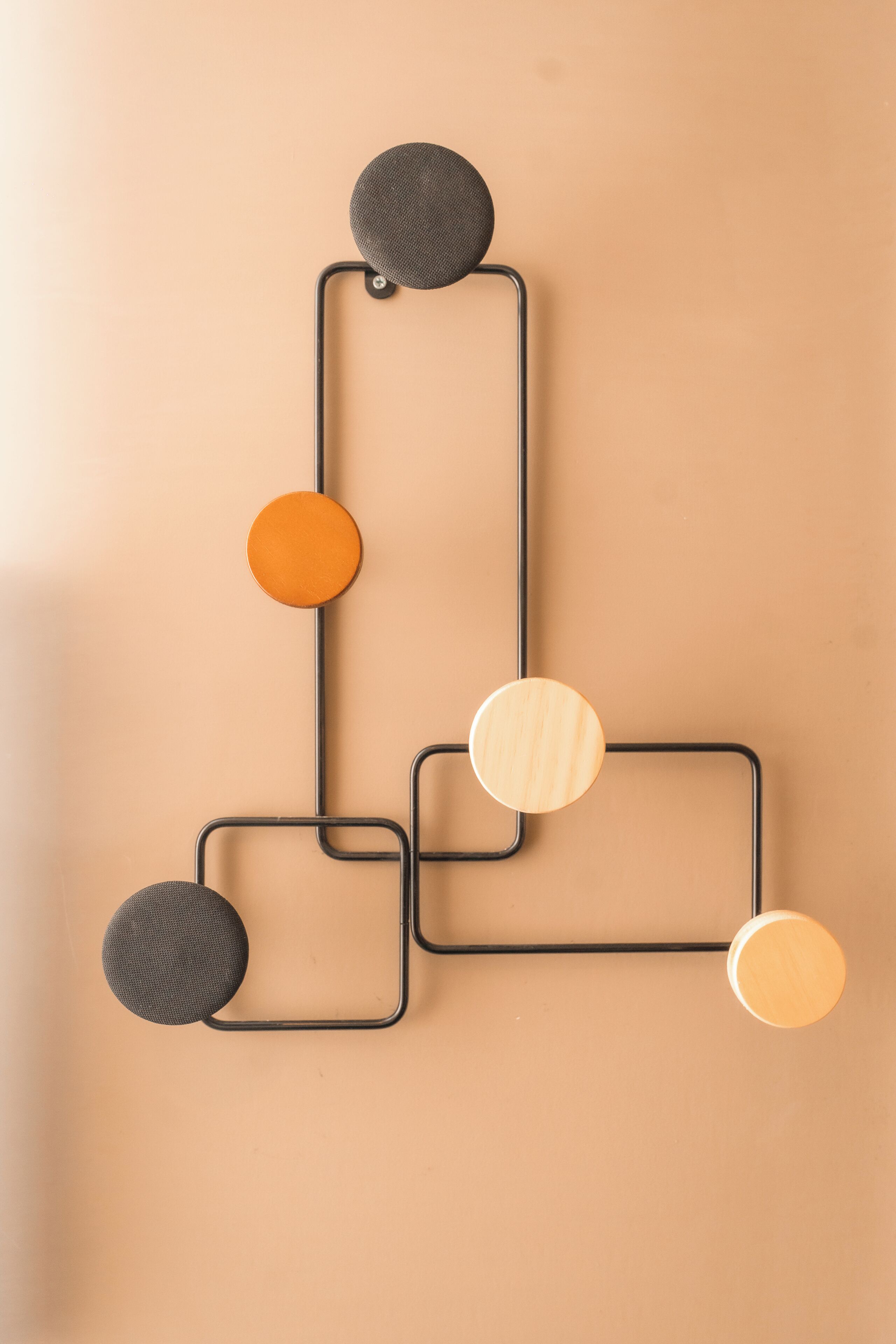 Een geometrische wanddecoratie met onderling verbonden vormen en ronde elementen.