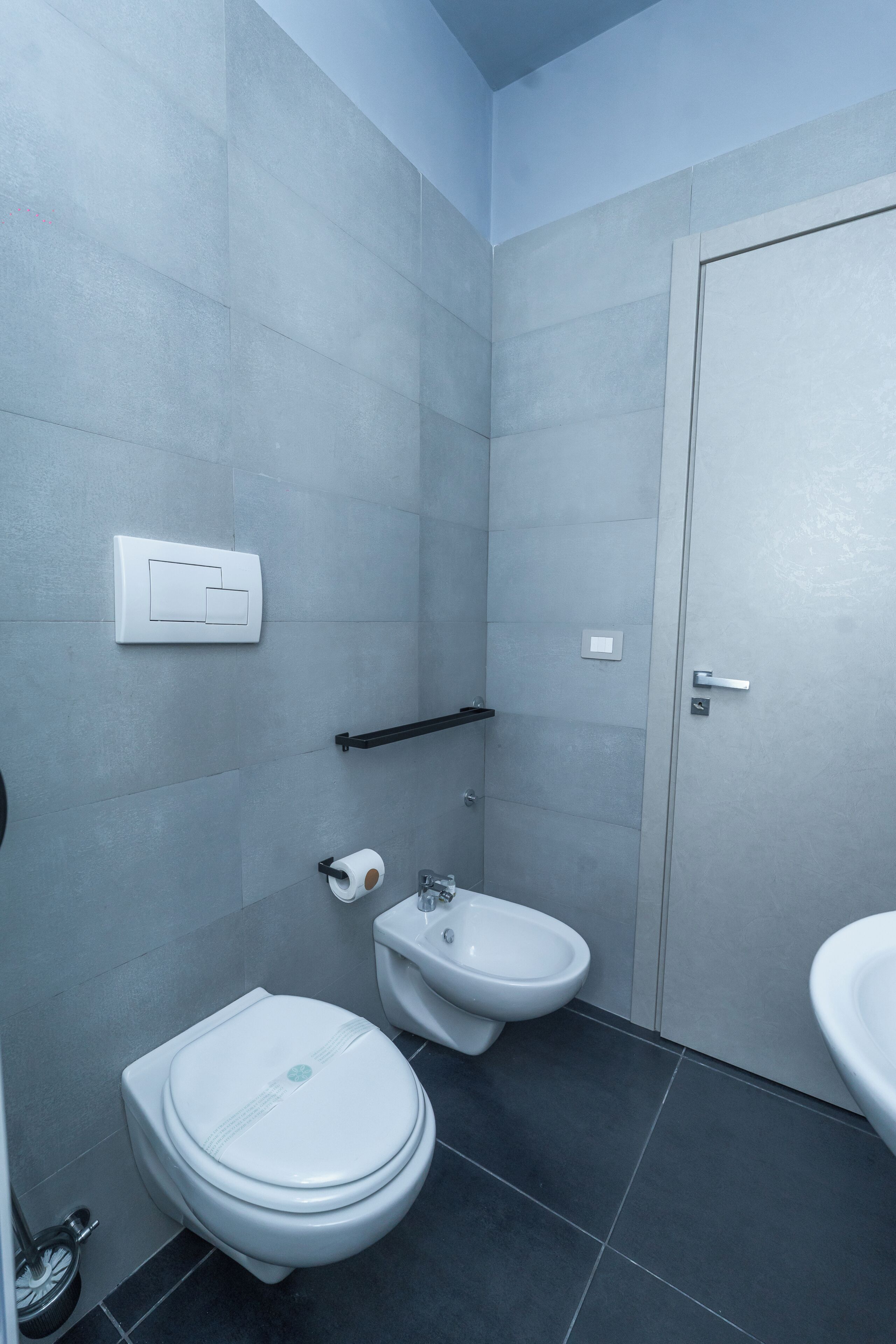Un baño con inodoro, bidé y lavamanos.