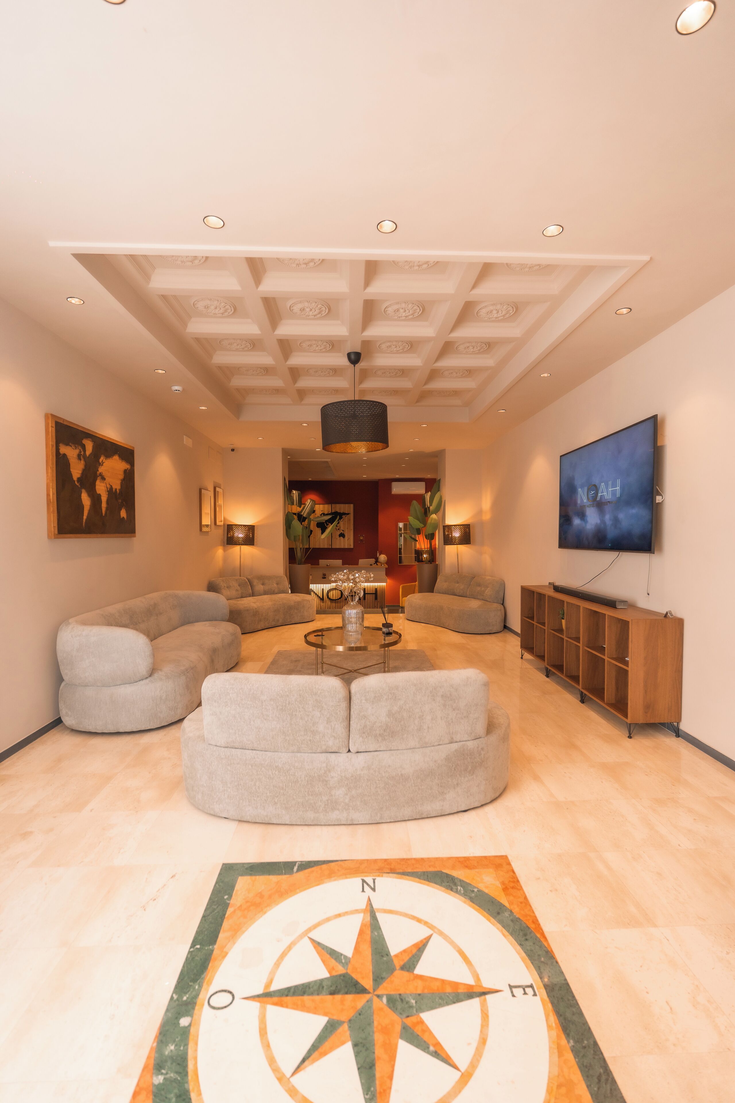 Un salon moderne avec un grand canapé, une table basse et un téléviseur fixé au mur.