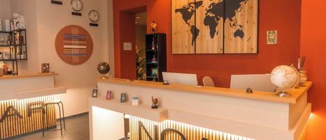 A reception area with a wooden reception desk, a world map on the wall, and a clock.