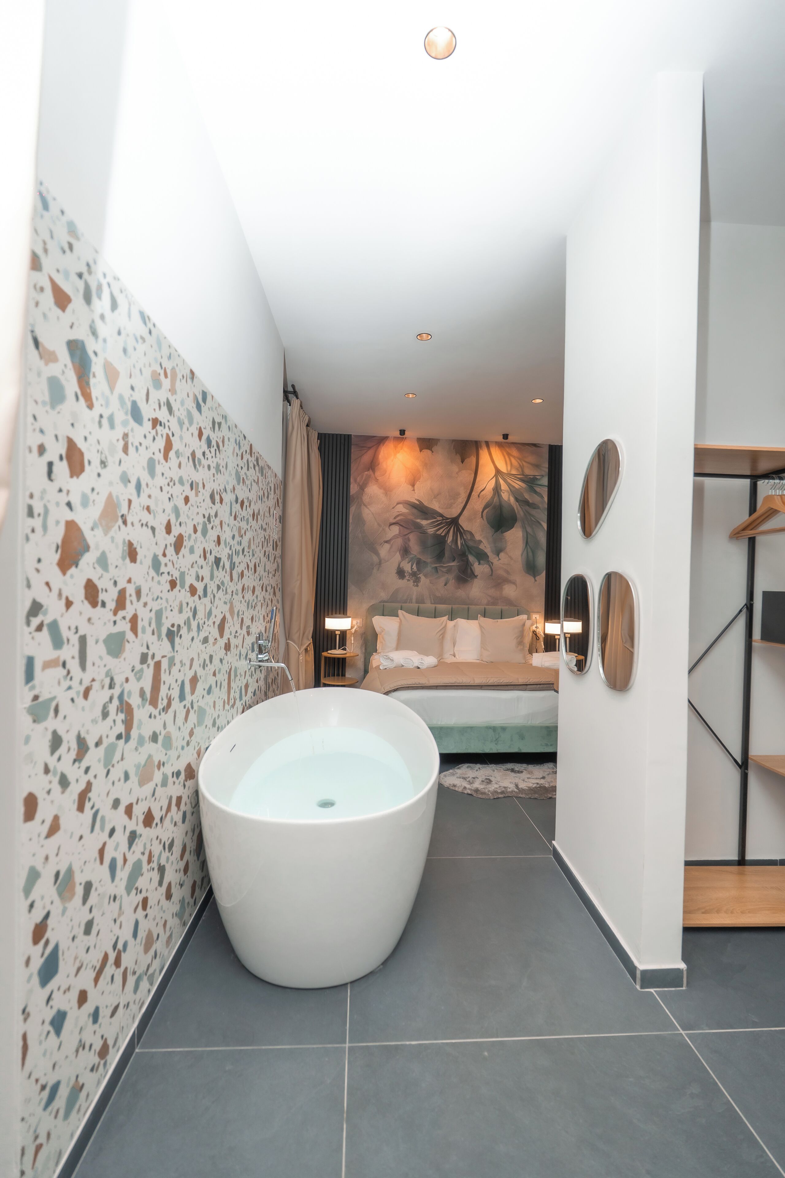 Une salle de bain moderne avec une baignoire sur pieds, une douche et un grand miroir.