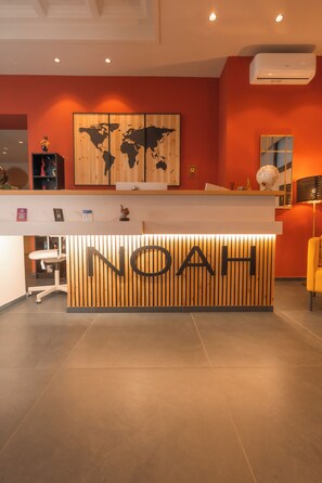 A reception desk with a wooden panel design and the word 'NOAH' prominently displayed. - Noah Gate Hotel & Suites (Naples)