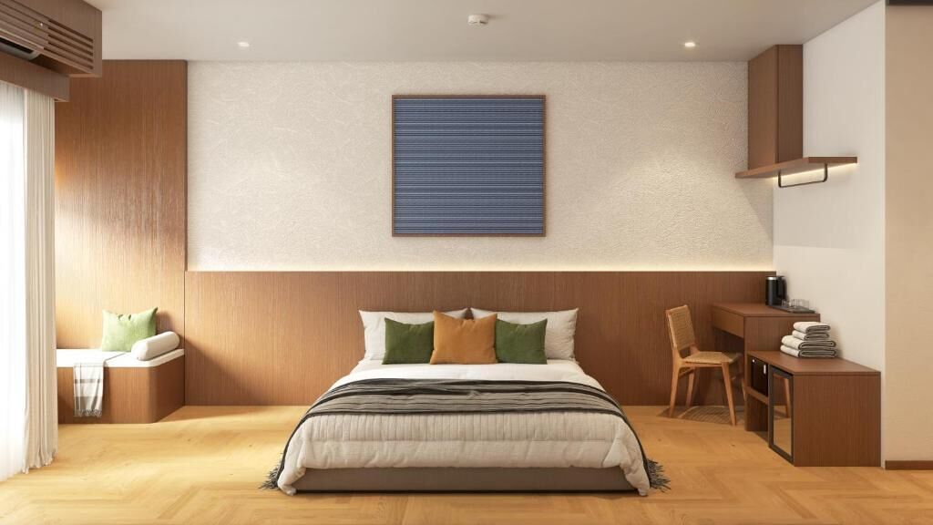 A modern bedroom with a bed, bedside table, chair, and a desk with a chair.