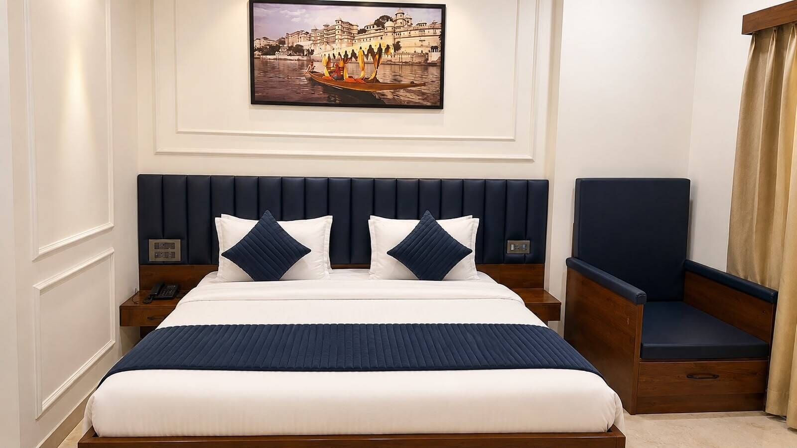 Een hotelkamer met een groot bed, een nachtkastje, een stoel en een schilderij aan de muur.