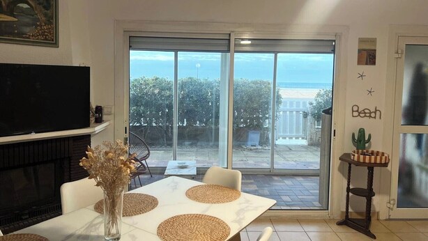 A dining area with a large table, chairs, and a TV on the wall.