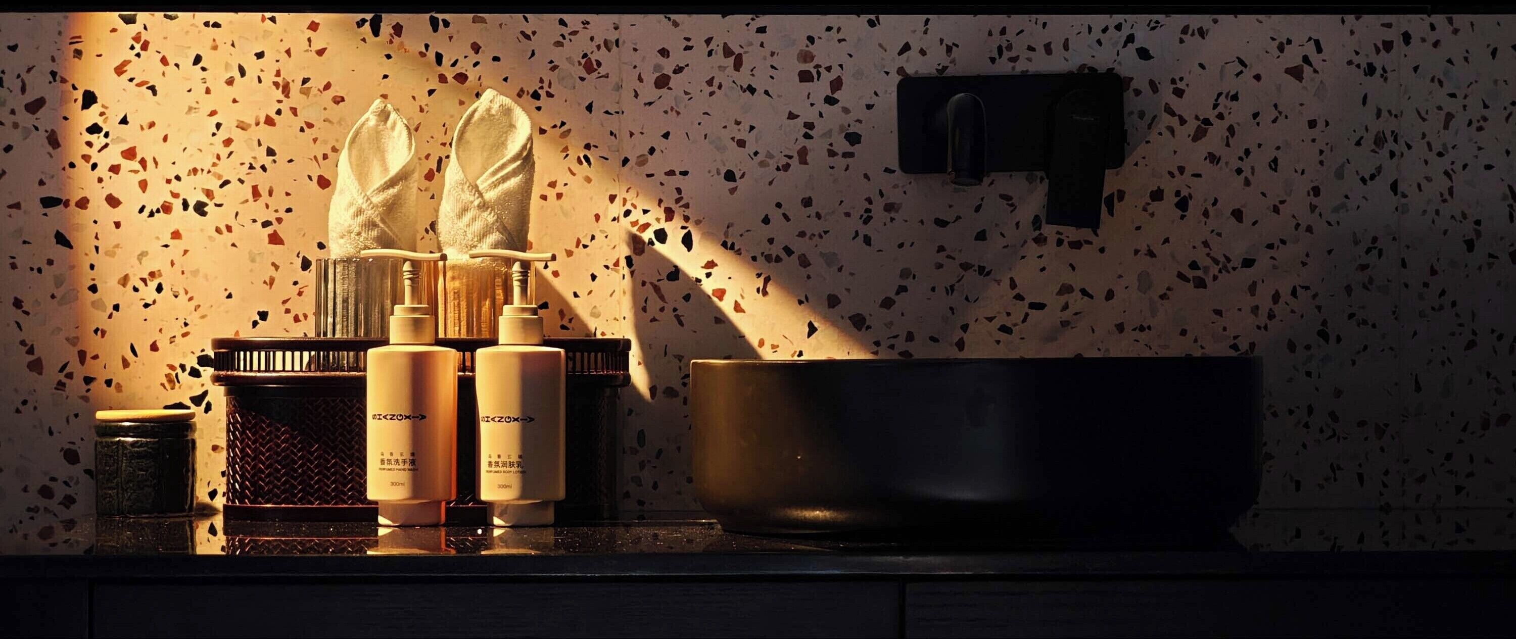 Una encimera de cocina con salpicadero moteado, un grifo negro y una olla grande.