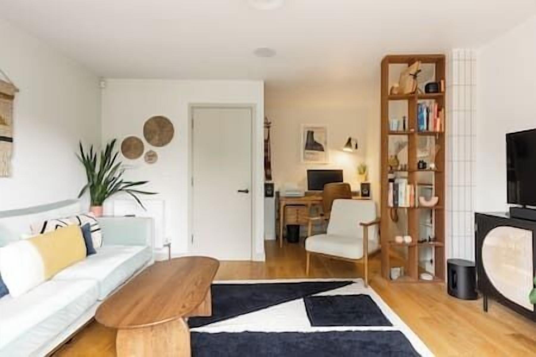 Een moderne woonkamer met een bank, een salontafel, een boekenkast en een televisie.