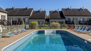 Ein Swimmingpool mit Liegestühlen und blauem Himmel.