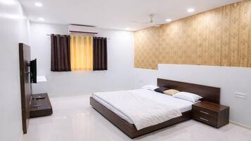 A modern hotel room with a large bed, bedside tables, a flat-screen TV, and a window with curtains.