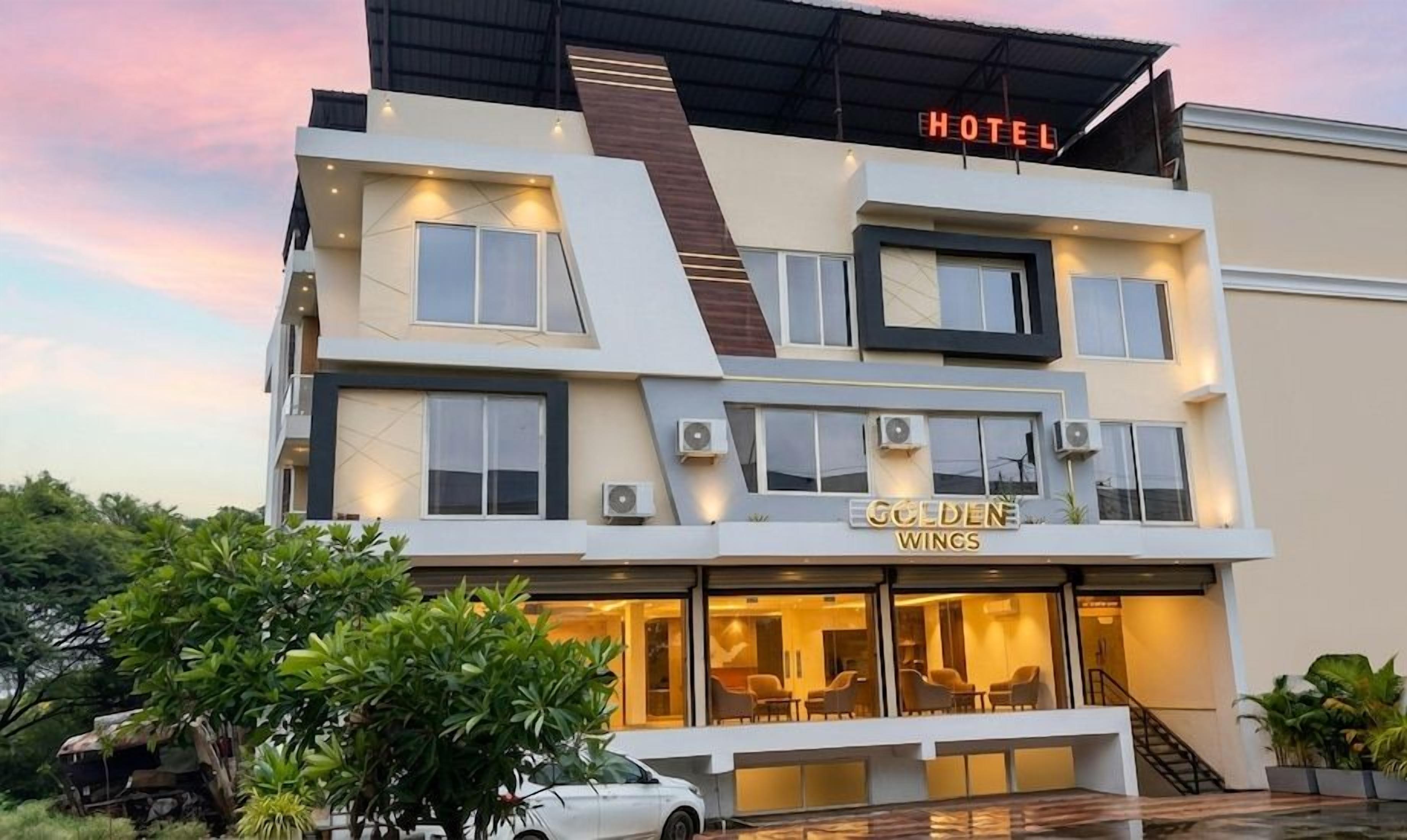Ein Hotel mit modernem Design, das mehrere Stockwerke umfasst und eine auffällige 'HOTEL'-Beschilderung zeigt.