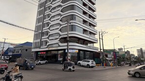 A multi-story hotel with a modern design, featuring balconies and large windows. - The Sky Plus (Sihanoukville)