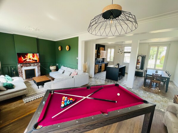 A living room with a pool table, a fireplace, and a dining area. - 🌸 Charming house with jacuzzi, billiard table & large garden 1 h 30 from Paris (Droué)