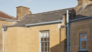 A stone building with a tiled roof, a central door, and a small courtyard. - King William Pub with Rooms (Bath)
