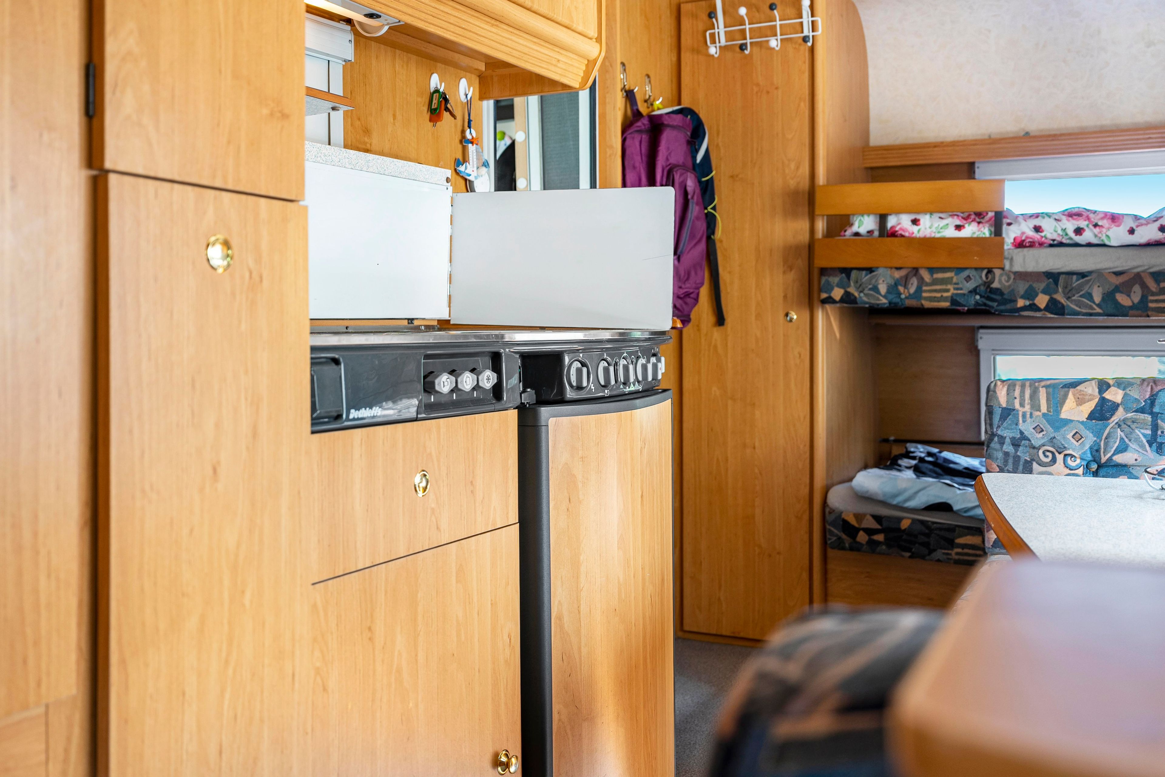 A compact kitchenette with a stove, oven, and a small refrigerator.
