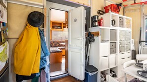 Ein kompakter Wohnbereich mit Küchenzeile, Essplatz und einer kleinen Sitzecke.