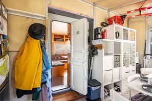 Un espai vital compacte amb una cuinetta, una zona de menjador i una petita zona de seients.