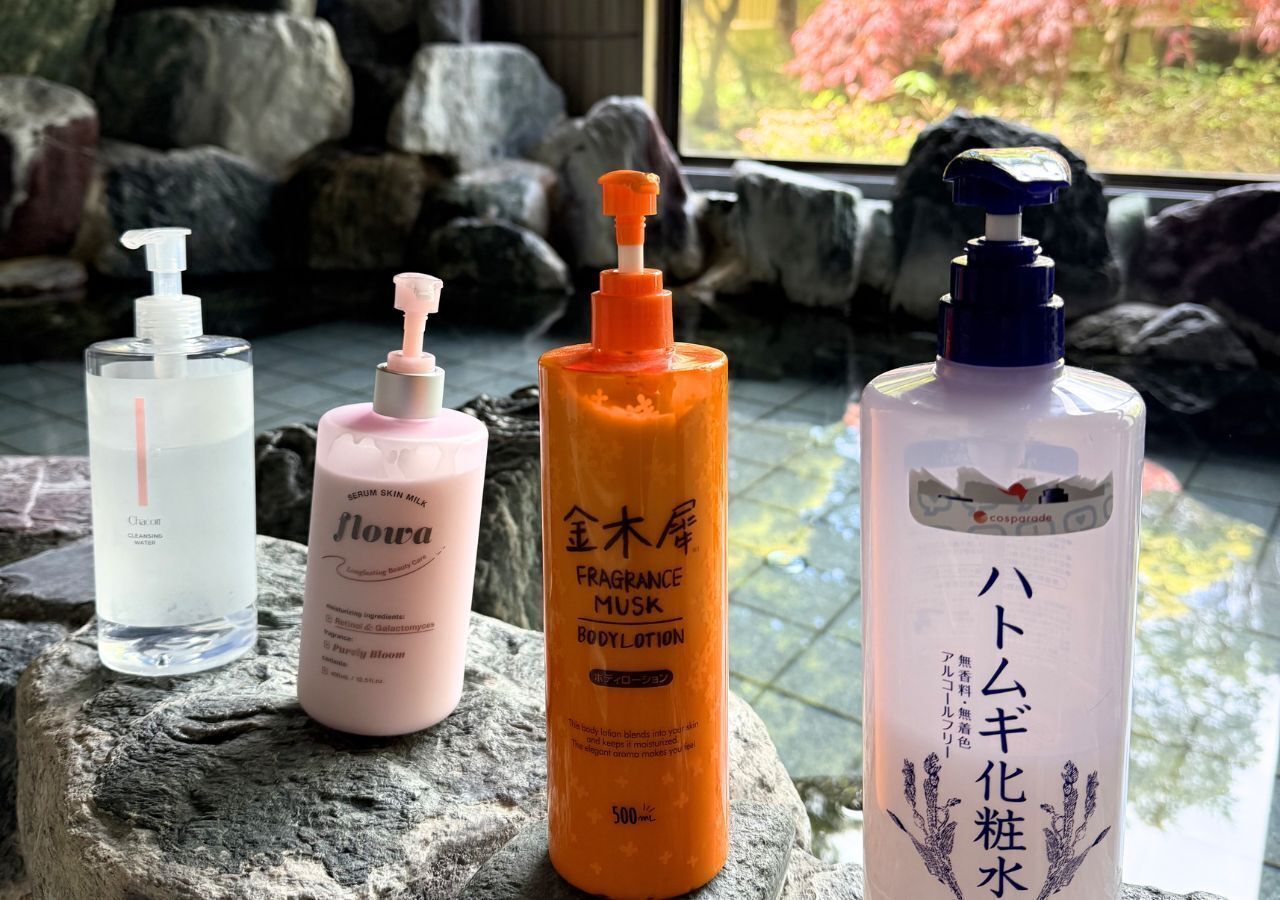 Four bottles of body lotion on a rock.