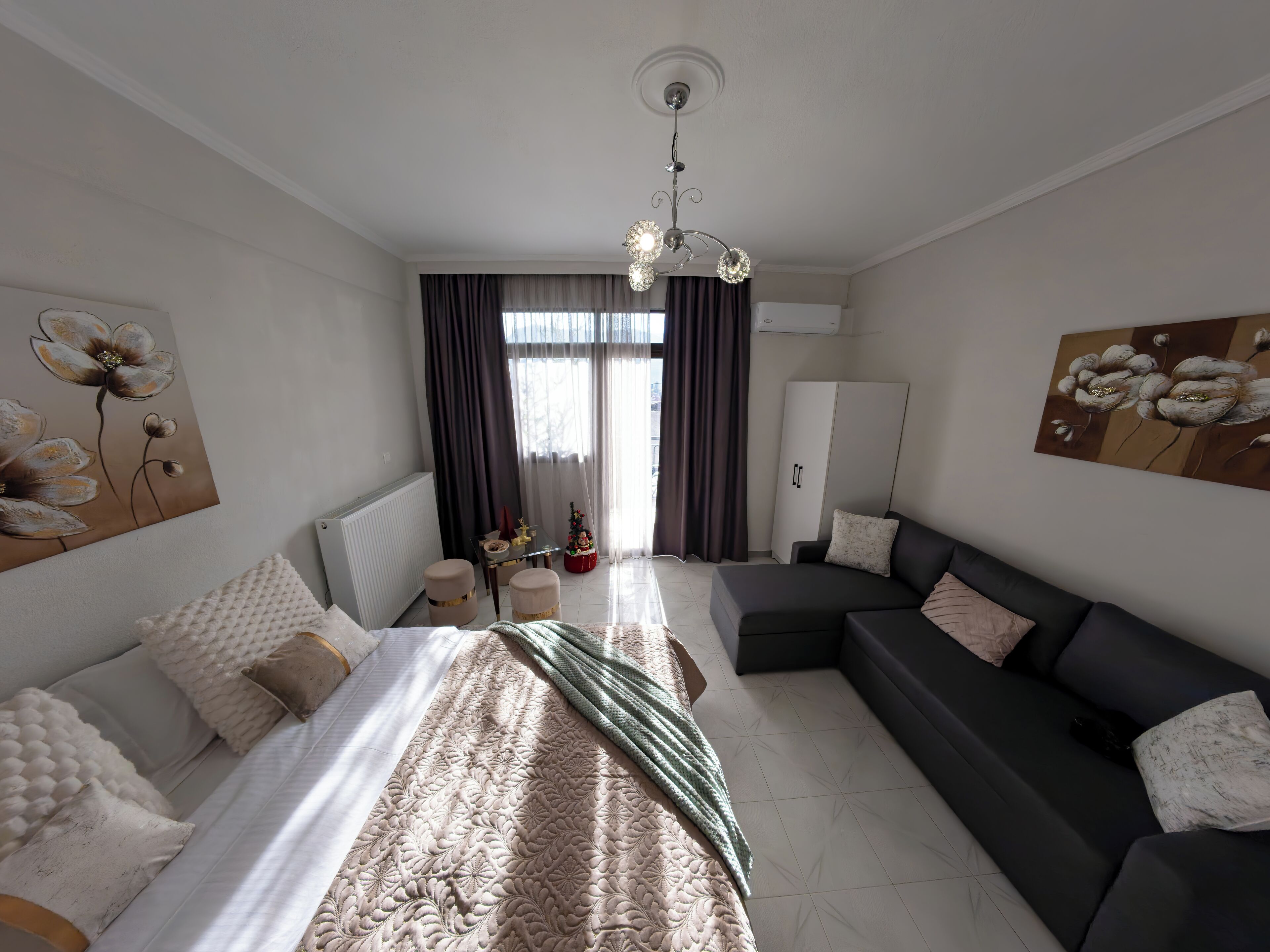 Une chambre à coucher moderne avec un lit, un canapé, une petite table et un radiateur.
