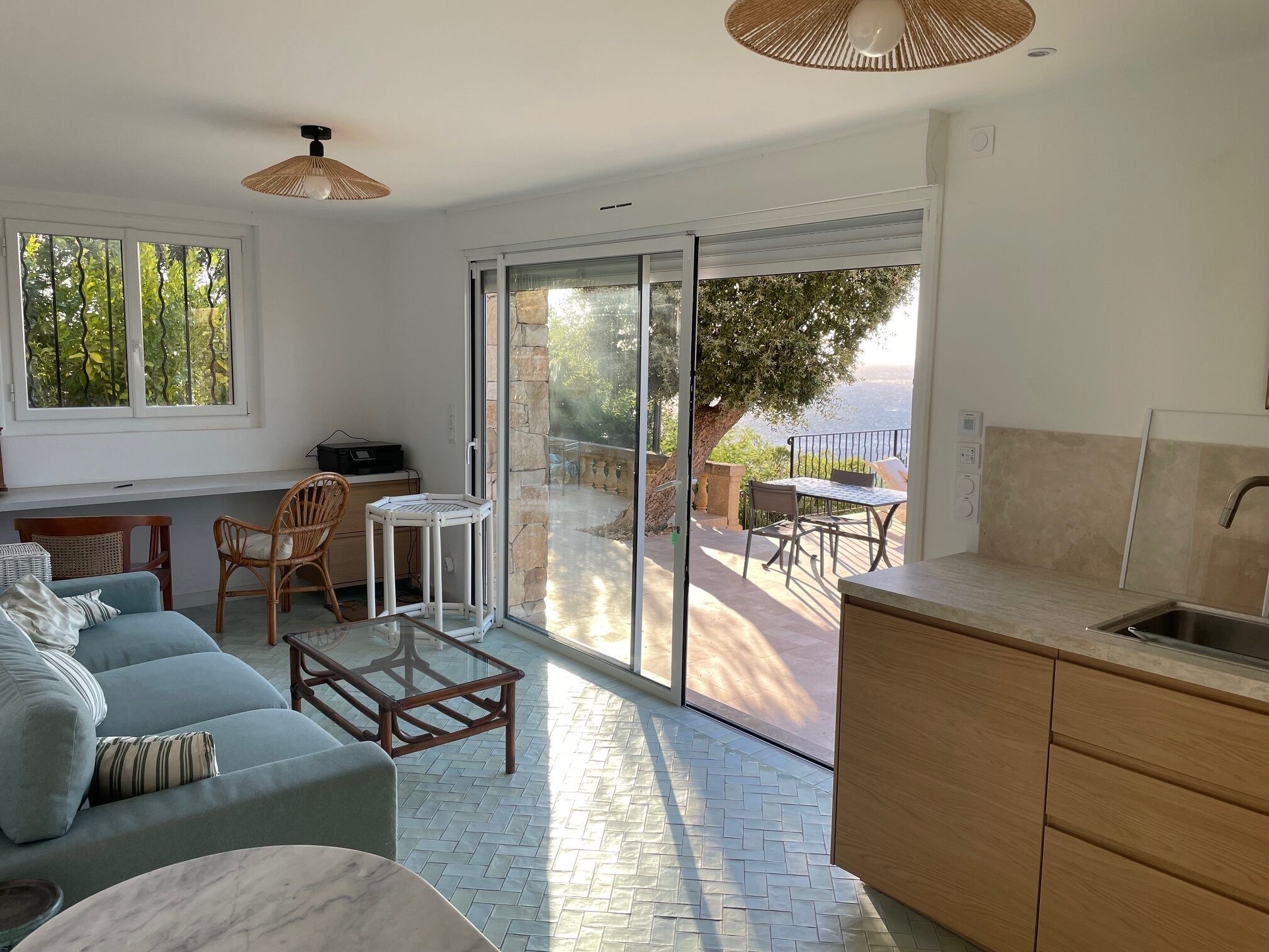 Une cuisine moderne dotée d’une porte-fenêtre coulissante donnant sur un patio.