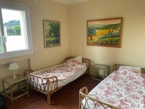 A room with two single beds, a small table, a lamp, and two paintings on the wall. - Spacious villa with breathtaking views of Saint-Tropez (Sainte-Maxime)