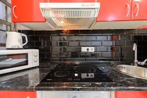 A kitchen with a microwave, stove, and sink. - M Pel300i Piso Acogedor de 1 Dormitorio en el Cen (Madrid)
