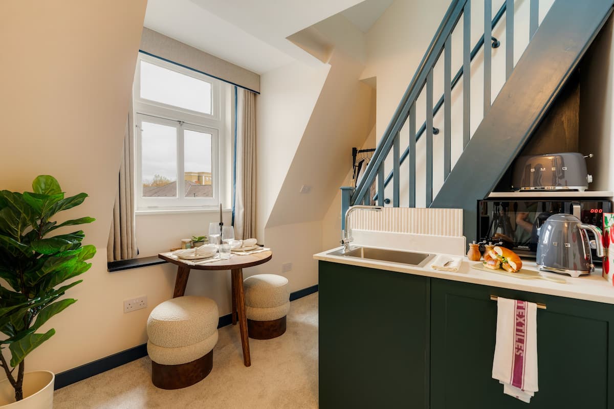 A compact kitchen with a window, a sink, a coffee maker, and a toaster.