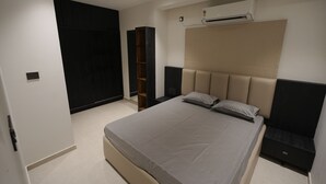 Ein modernes Schlafzimmer mit Bett, Einbauschränken und einer Klimaanlage.