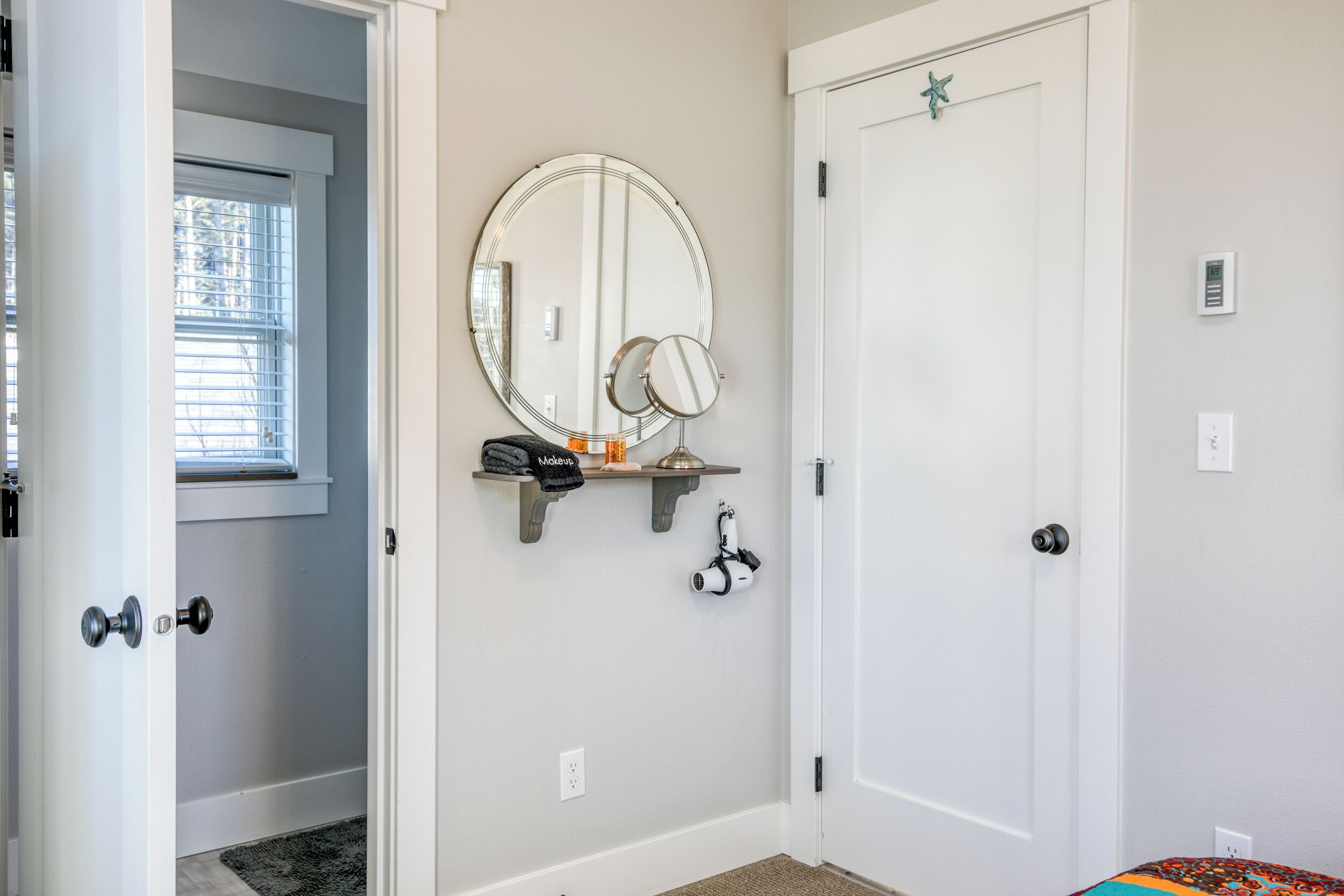 A bathroom with a large mirror, a towel rack, and a door with a star decoration.