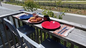 Ein Balkon mit Frühstücksangeboten, darunter Croissants und eine Kaffeetasse, mit Blick auf eine Häuserreihe und eine Straße.