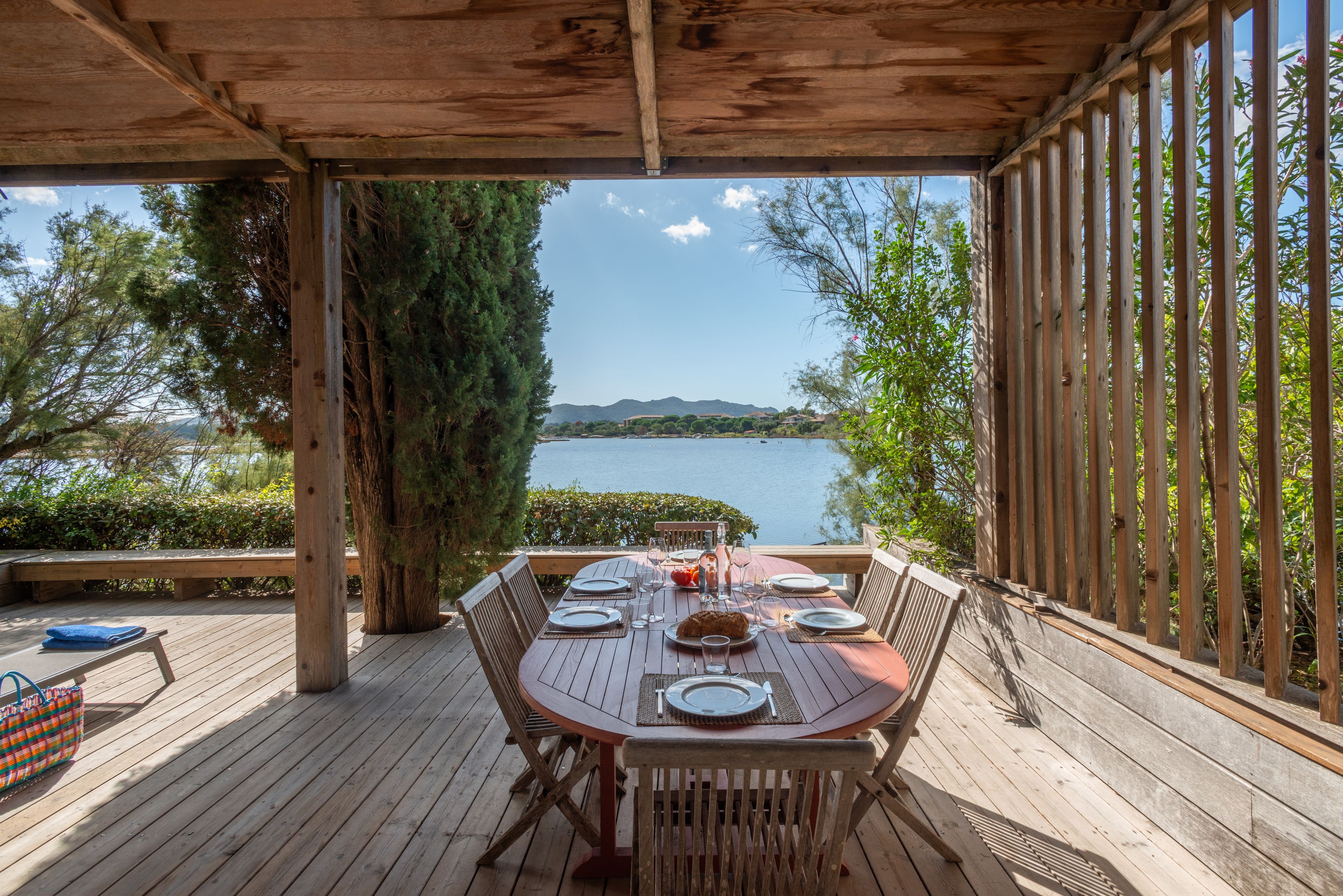 Un espace extérieur aménagé pour prendre les repas, avec vue sur un lac et des montagnes.