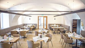 Um restaurante amplo com tetos altos, diversas áreas de estar e um corredor central.