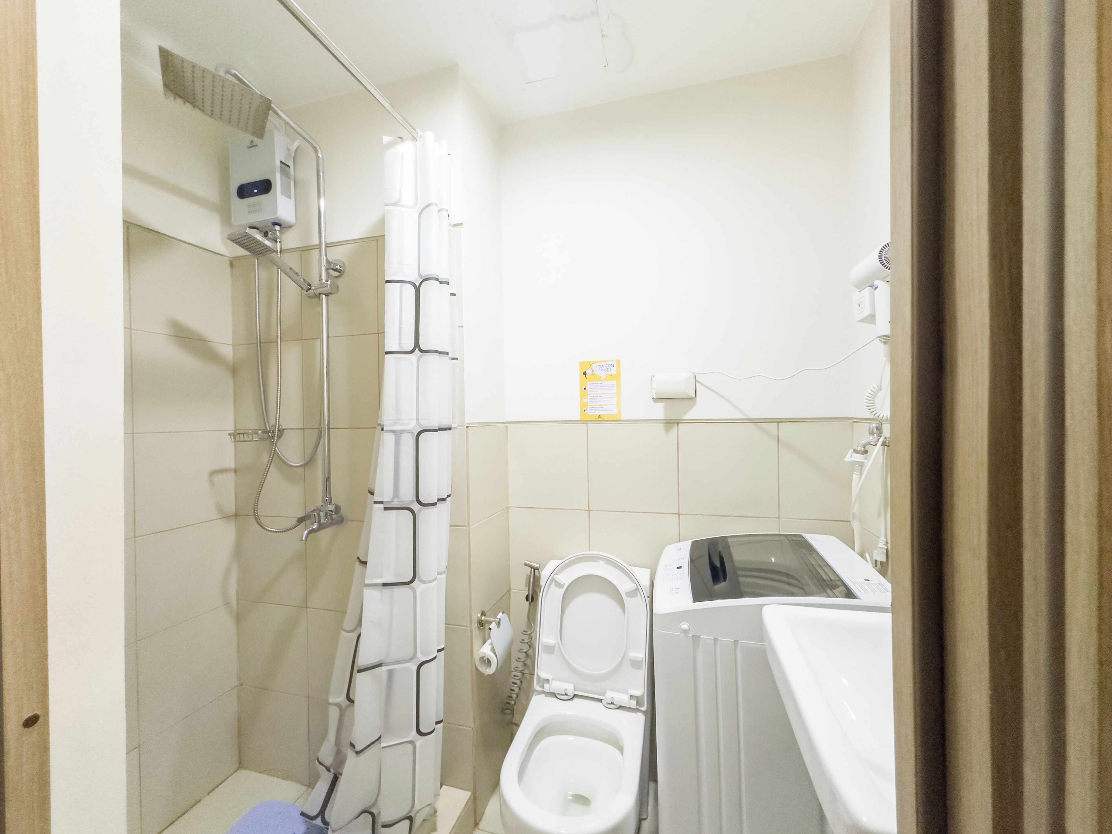 A small bathroom with a shower, toilet, and a towel rack.