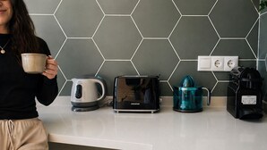 A kitchen with a hexagonal tile backsplash, a kettle, a toaster, and a coffee maker. - Beach Apartment | 1BR | 2 Guests | AC & WIFI (Valencia)