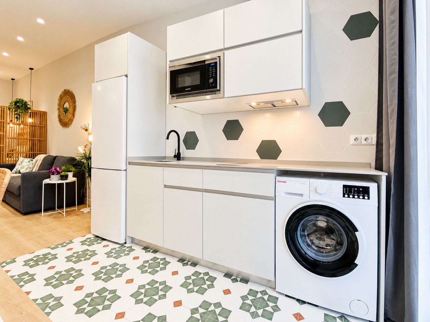 Een moderne keuken met een inbouw wasmachine, een magnetron en een spoelbak.