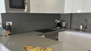 Una cocina moderna con una isla central, electrodomésticos de acero inoxidable y un diseño de encimera elegante.