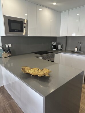 Eine moderne Küche mit Kochinsel, Edelstahlgeräten und einem eleganten Arbeitsplatten-Design.
