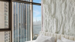 A bedroom with a large window, a bed with white linens, and a view of high-rise buildings and a city skyline. - Serene 1BR Escape with Burj Khalifa View (Dubai)